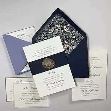 Gold foil with navy blue invitation. Gold wax seal on belly band. Fabric envelope liner.